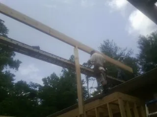 Carpenter setting a ridge beam over a new addition frame — Ice Dam Removal by Roofing Brothers in Rutherford