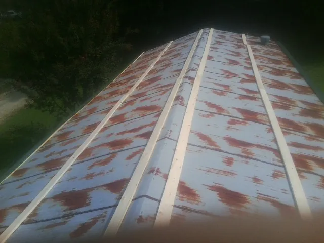 Rusted metal roof panels with new wood purlins before replacement — Storm Damage Roof Repair in Rutherford by Roofing Brothers