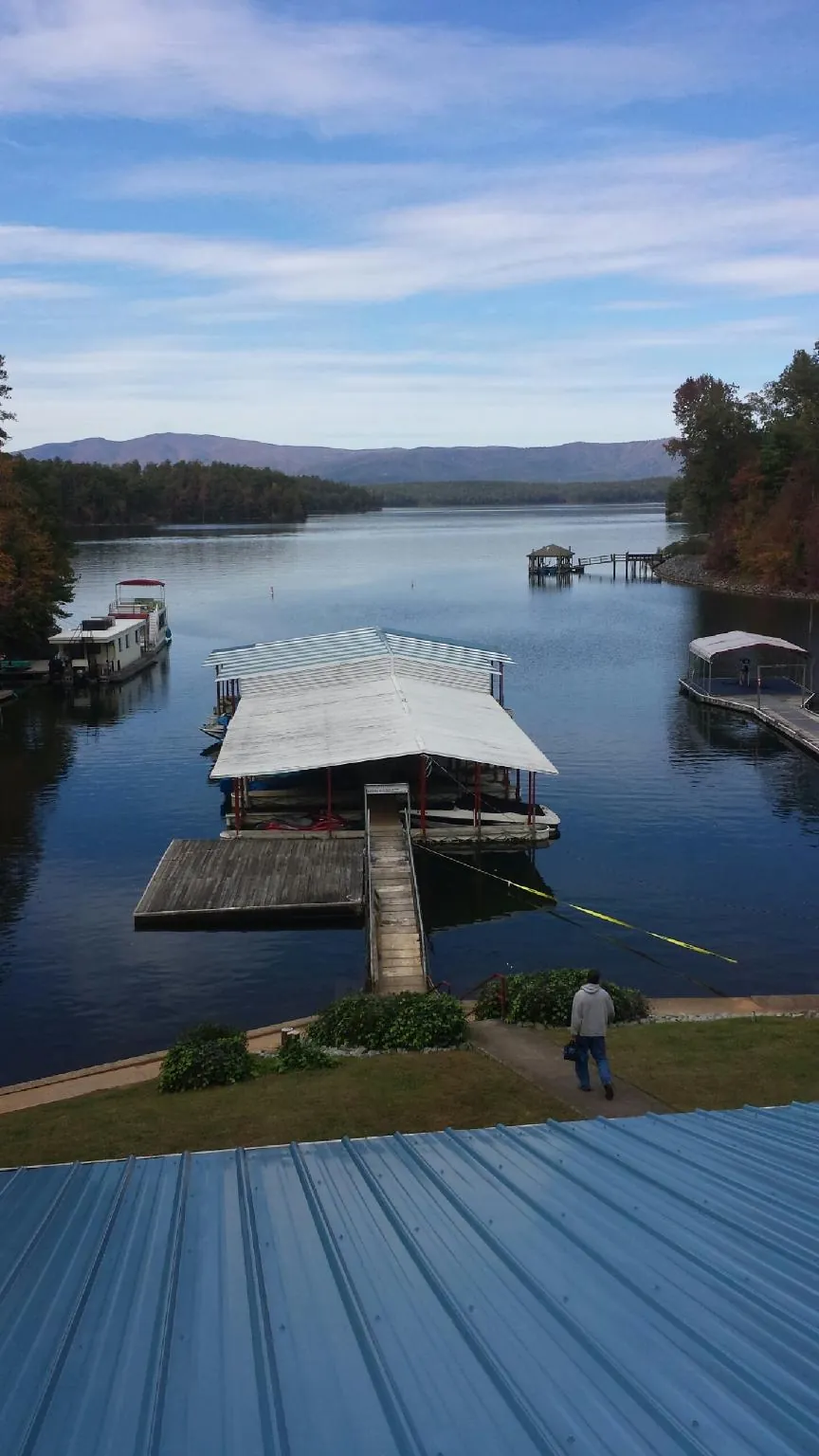 View across a lake from a newly installed blue metal roof in Rutherford