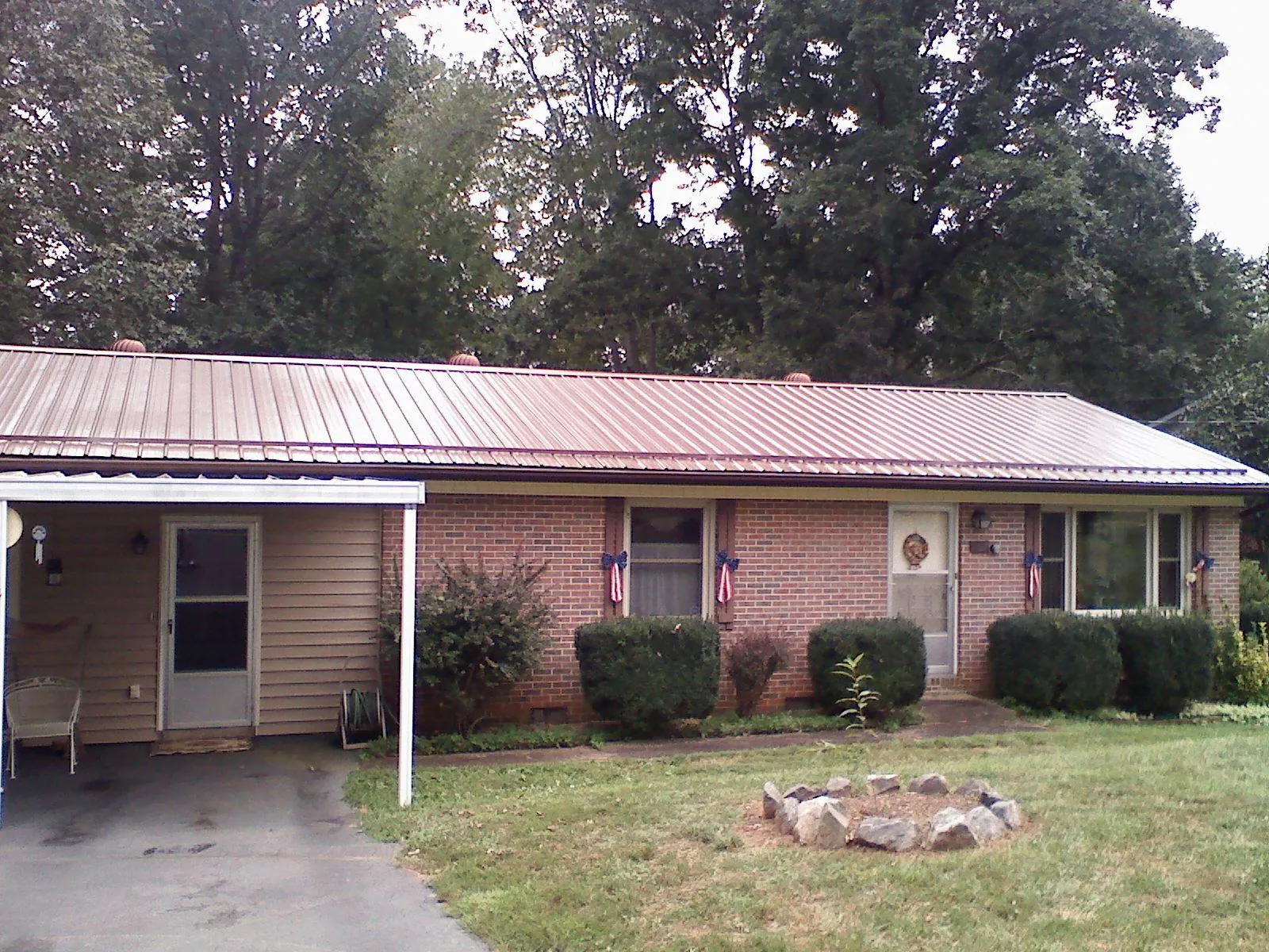 Bronze metal roof and carport on a brick ranch home — Roof Repair work by our crew in Rutherford